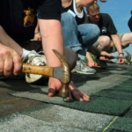 A roofing crew installs shingles on a house in Fort Lauderdale, Florida during a Habitat for Humanity project. U.S. Navy photo, public domain, via Wikimedia Commons