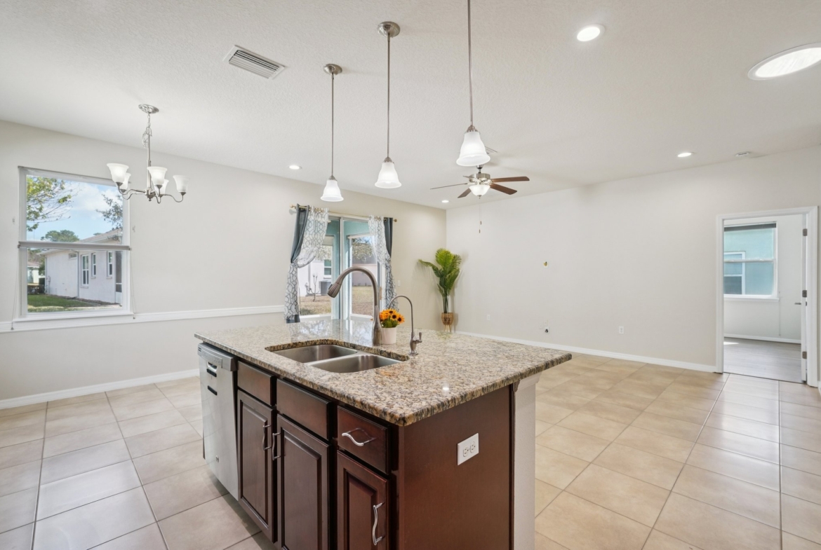 Kitchen with cozy eat-in dinette and granite counters in this 55+ New Port Richey home for sale