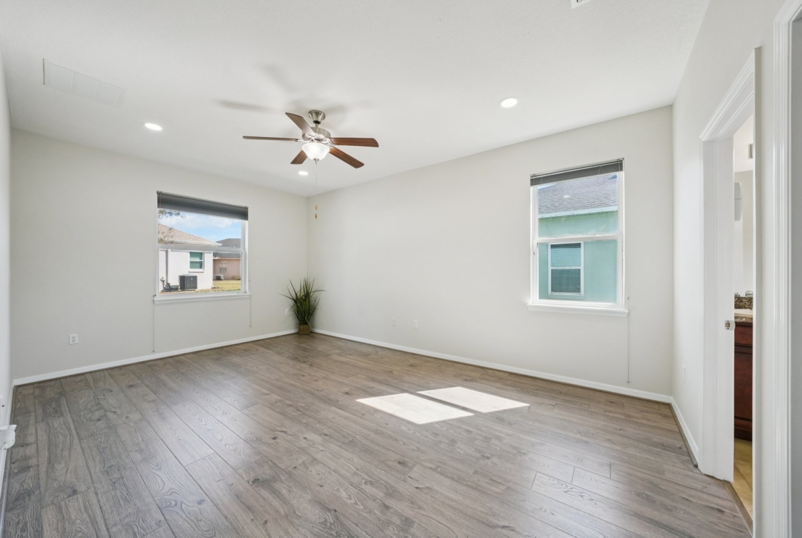 Bedroom with ceiling fan and laminate flooring in this split floor plan home, New Port Richey FL