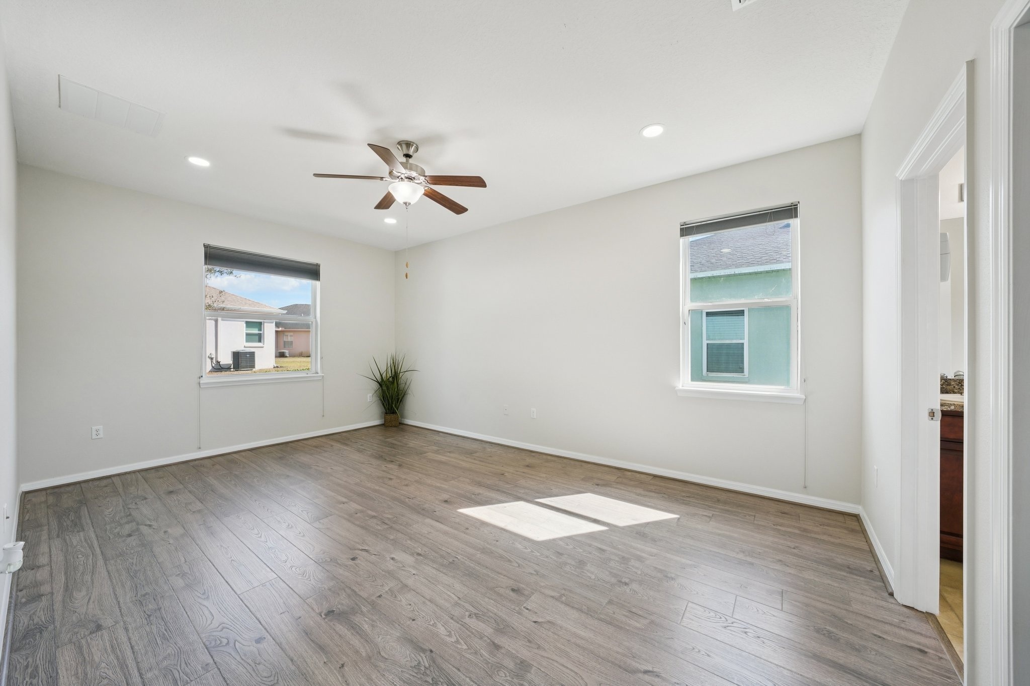 Bedroom with ceiling fan and laminate flooring in this split floor plan home, New Port Richey FL