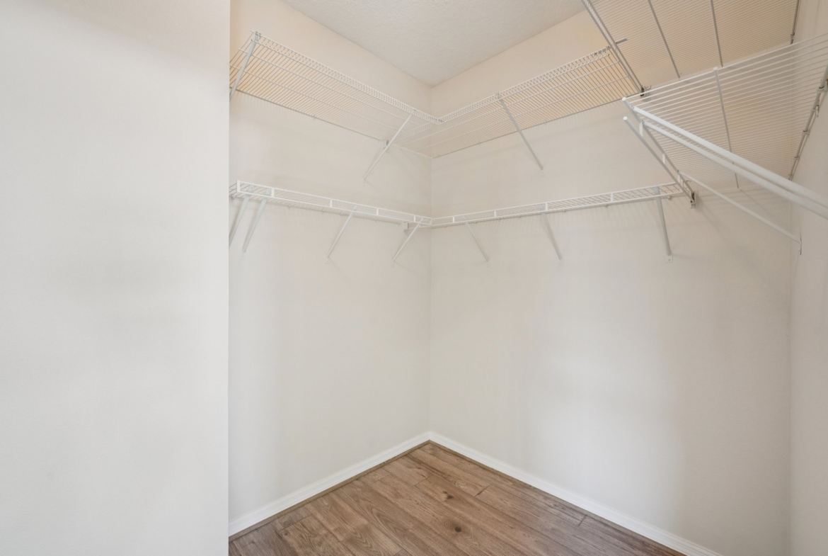 Primary suite walk-in closet with shelving at 11129 Kiskadee Cir, New Port Richey FL 34654