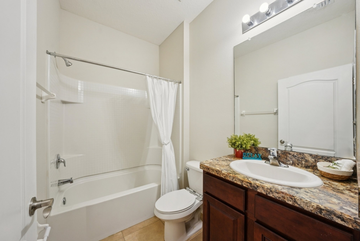 Guest bathroom with granite vanity and tub shower combination in New Port Richey FL 34654