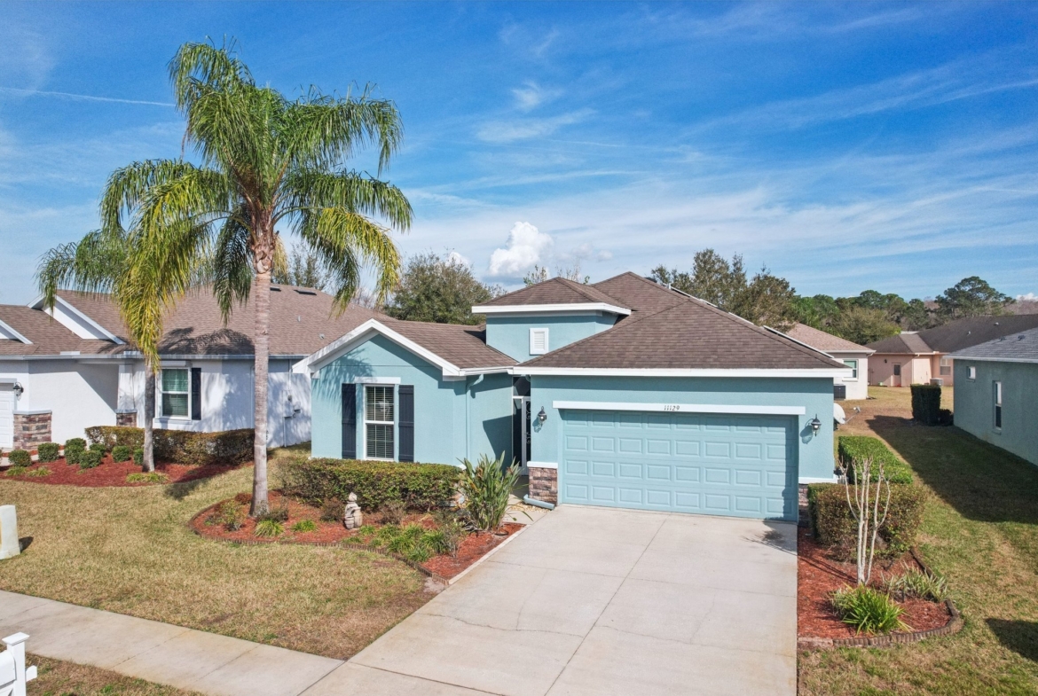 Front exterior with 2-car garage and driveway in Summertree, New Port Richey FL
