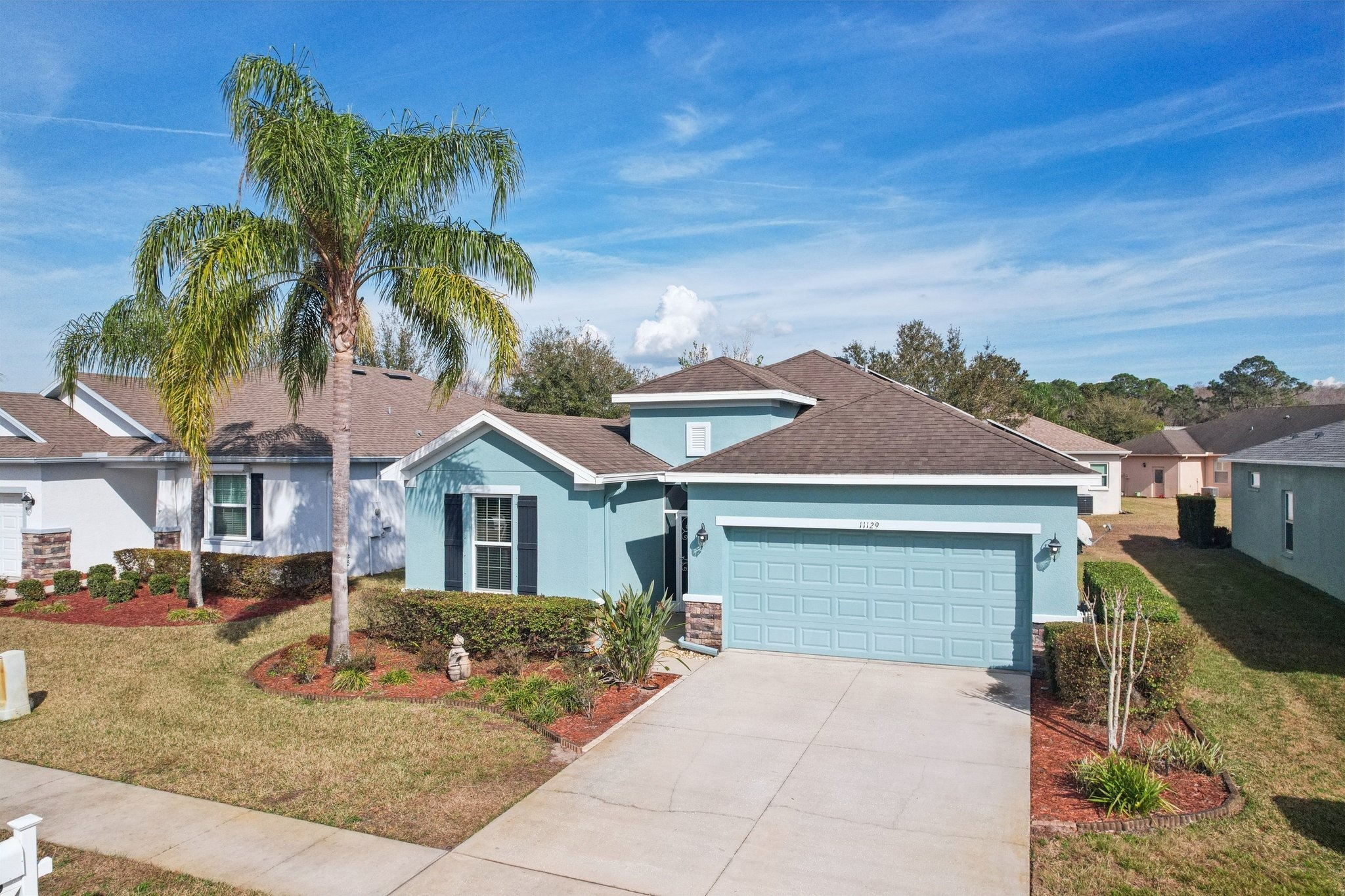 Front exterior with 2-car garage and driveway in Summertree, New Port Richey FL