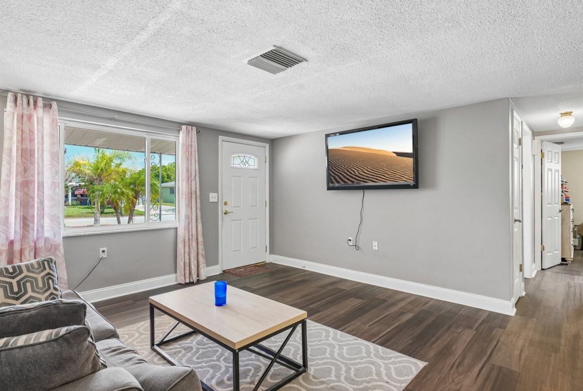 Spacious great room with tile flooring and sliders to the screened lanai at 1133 Grand Blvd, Holiday FL