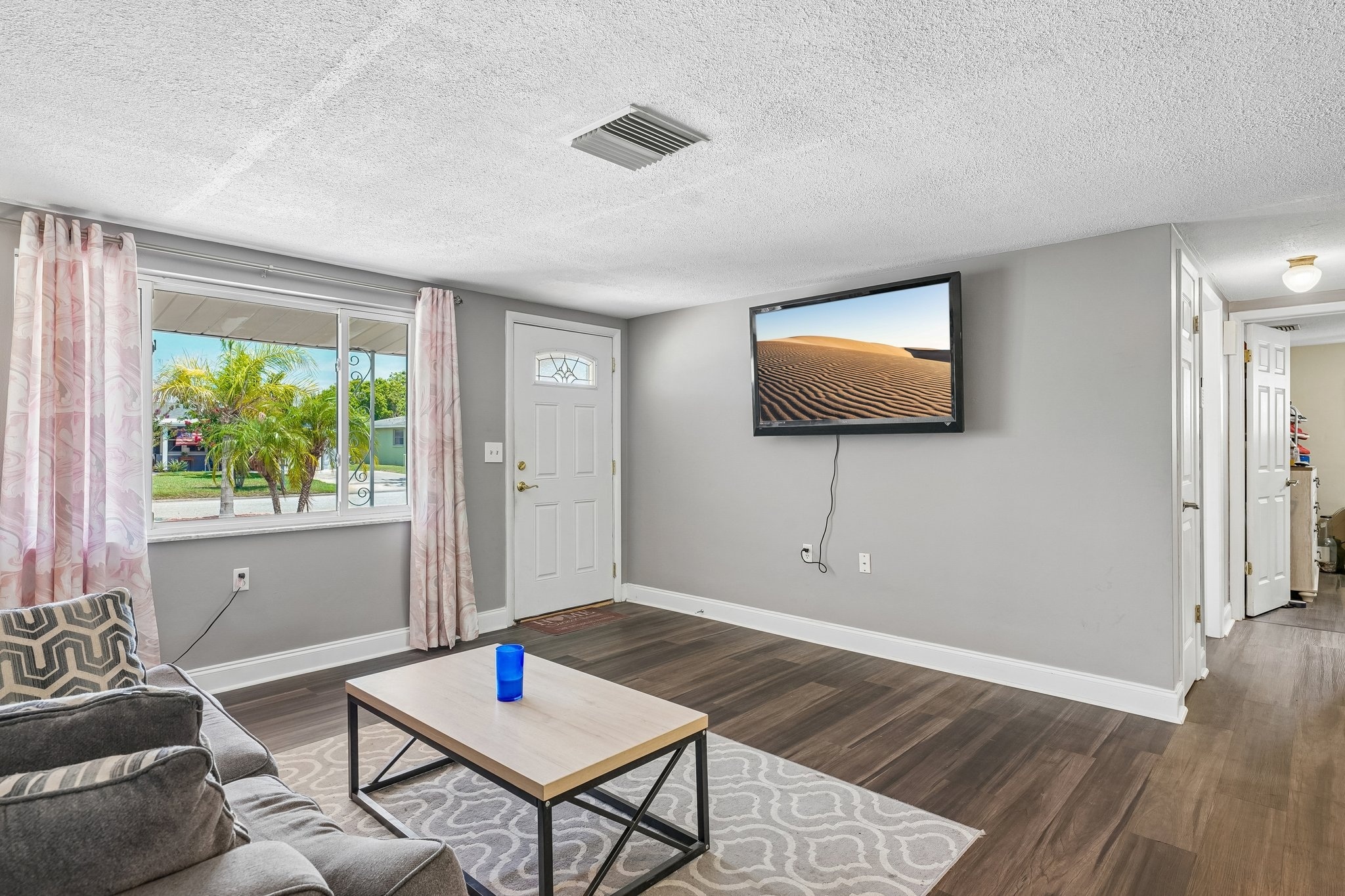 Spacious great room with tile flooring and sliders to the screened lanai at 1133 Grand Blvd, Holiday FL