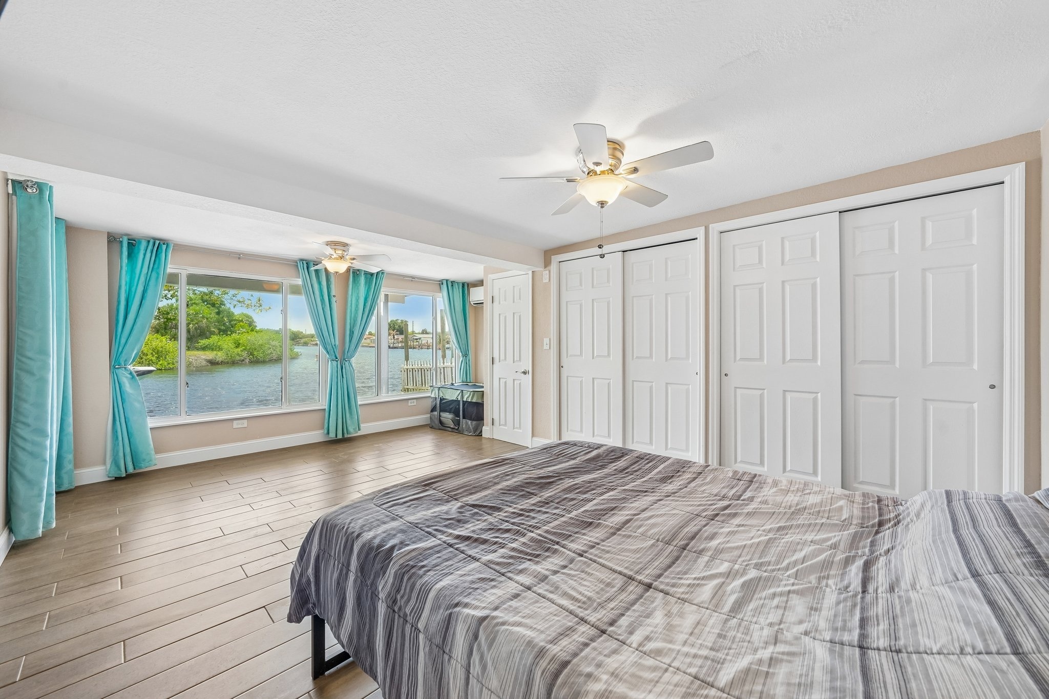 Bedroom with sliding closet doors and windows overlooking the Anclote River in Holiday FL