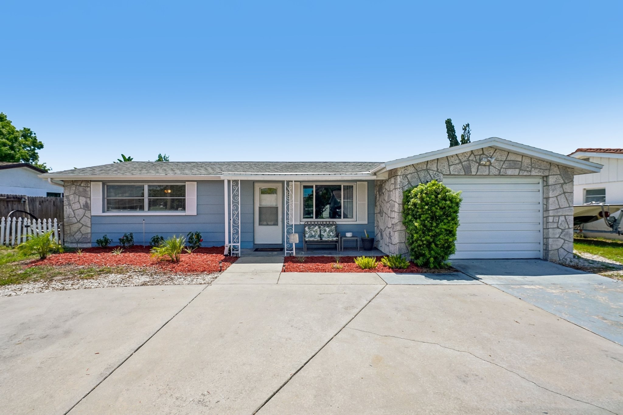 Front exterior with grand circular driveway and updated landscaping at 1133 Grand Blvd, Holiday FL