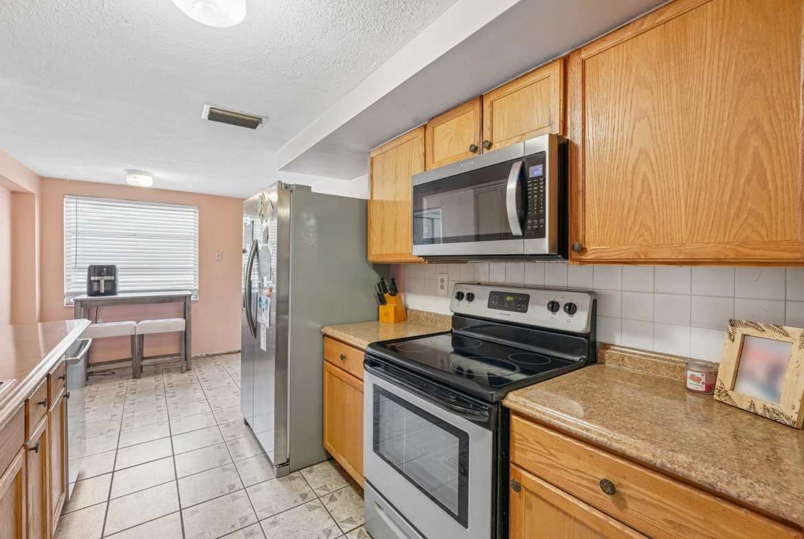 Kitchen with electric range, microwave and solid surface counters at 1133 Grand Blvd, Holiday FL