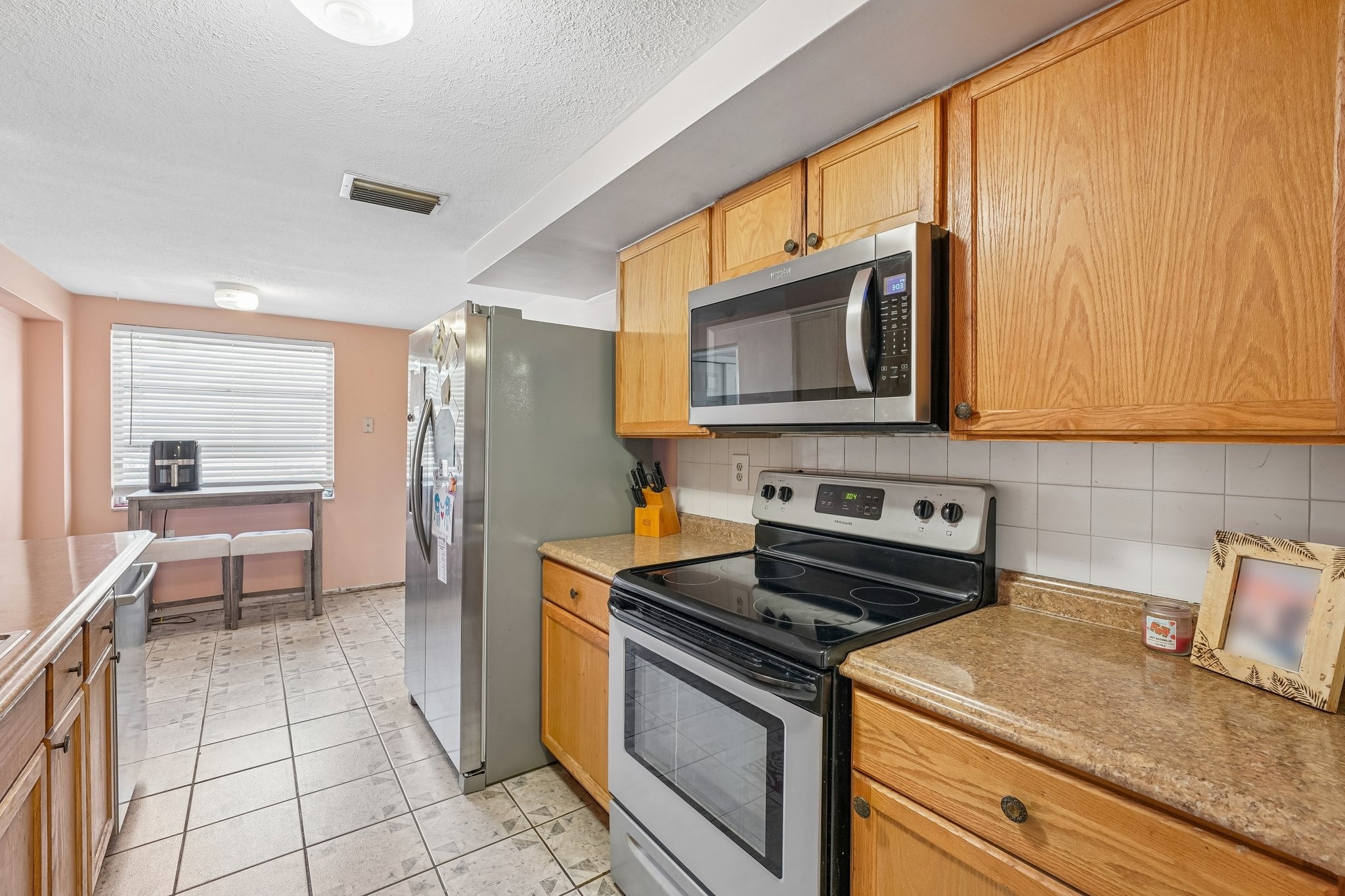 Kitchen with electric range, microwave and solid surface counters at 1133 Grand Blvd, Holiday FL