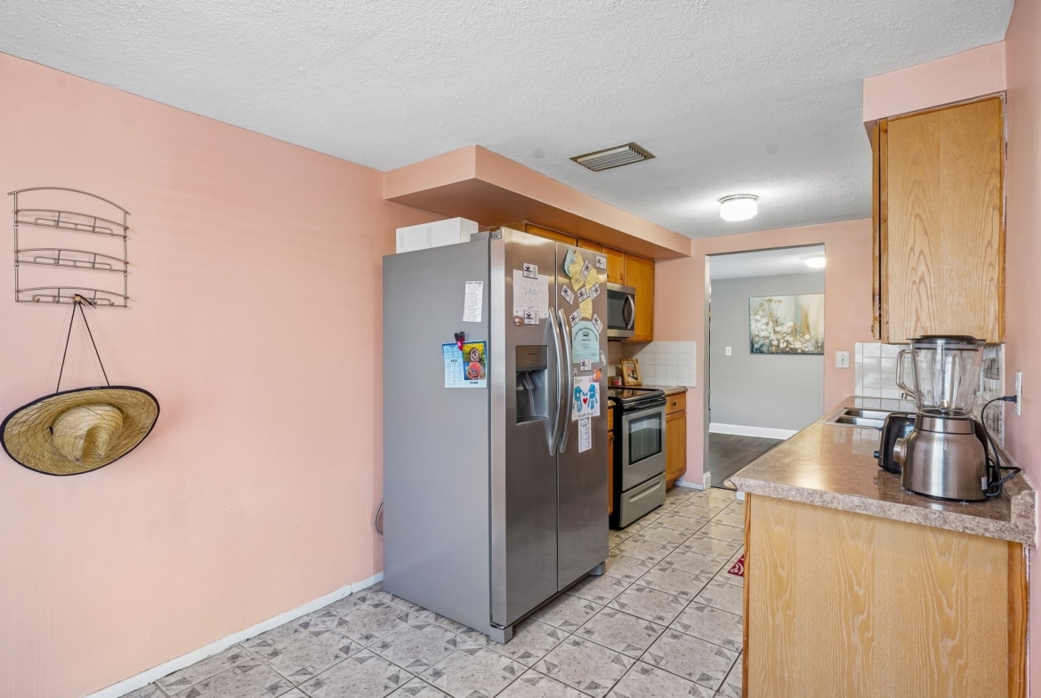 Kitchen with premium refrigerator and pass-through to the living area, Holiday FL 34690