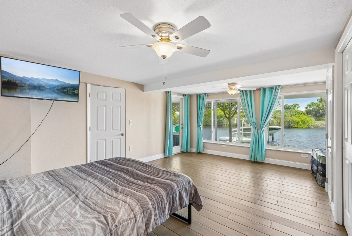 Primary suite with dramatic floor-to-ceiling windows overlooking the Anclote River, Holiday FL