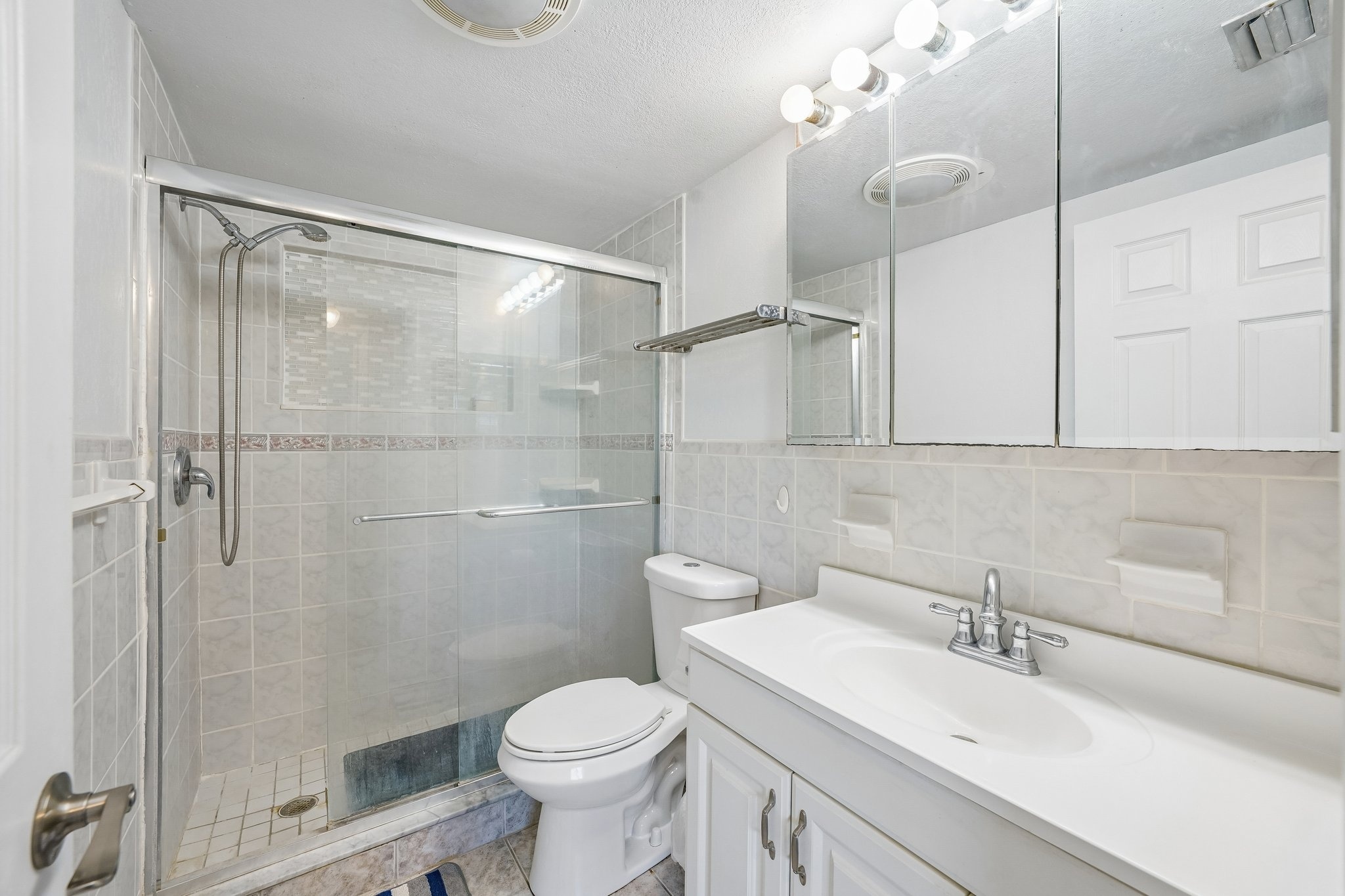 Renovated bathroom with walk-in shower, glass backsplash and supportive grab bars in Holiday FL