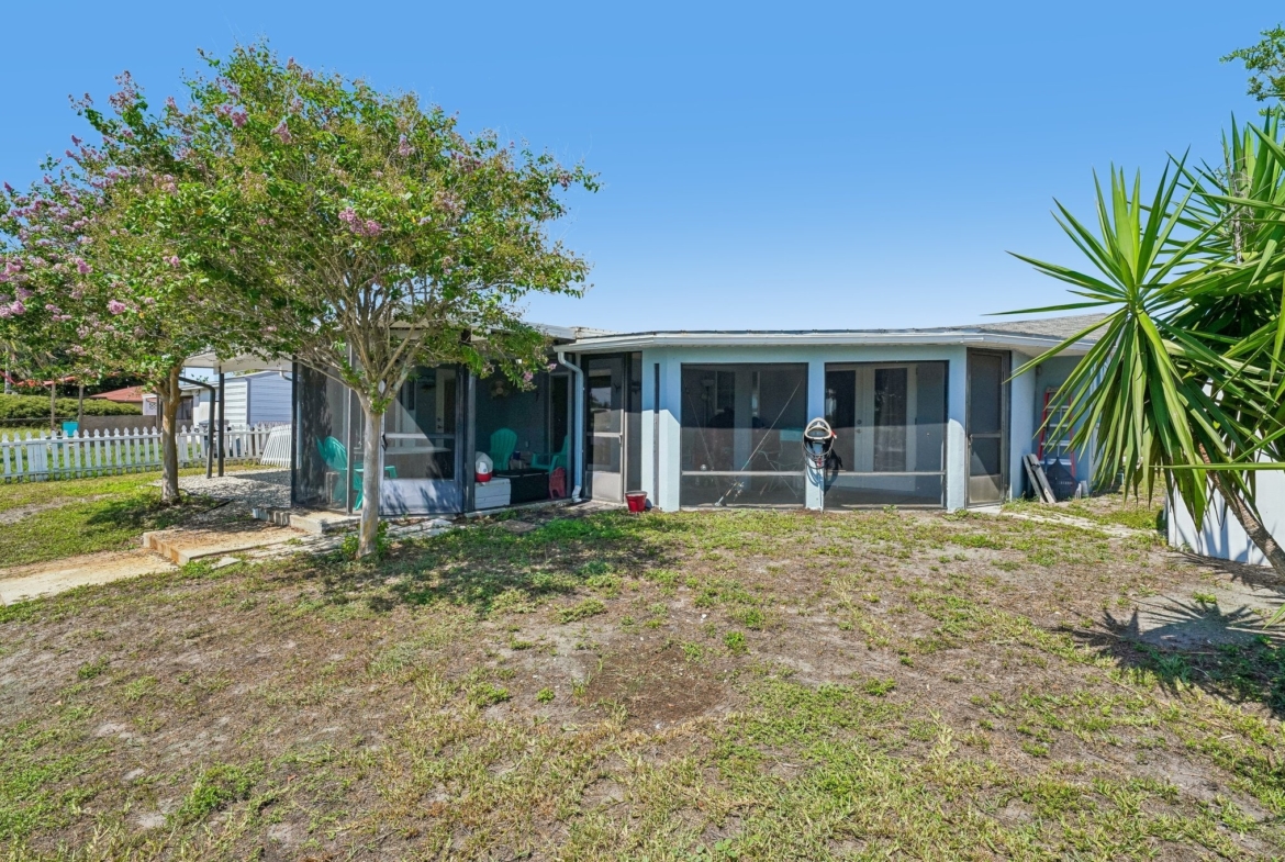 Fenced green space and updated landscaping behind this Holiday FL waterfront home for sale