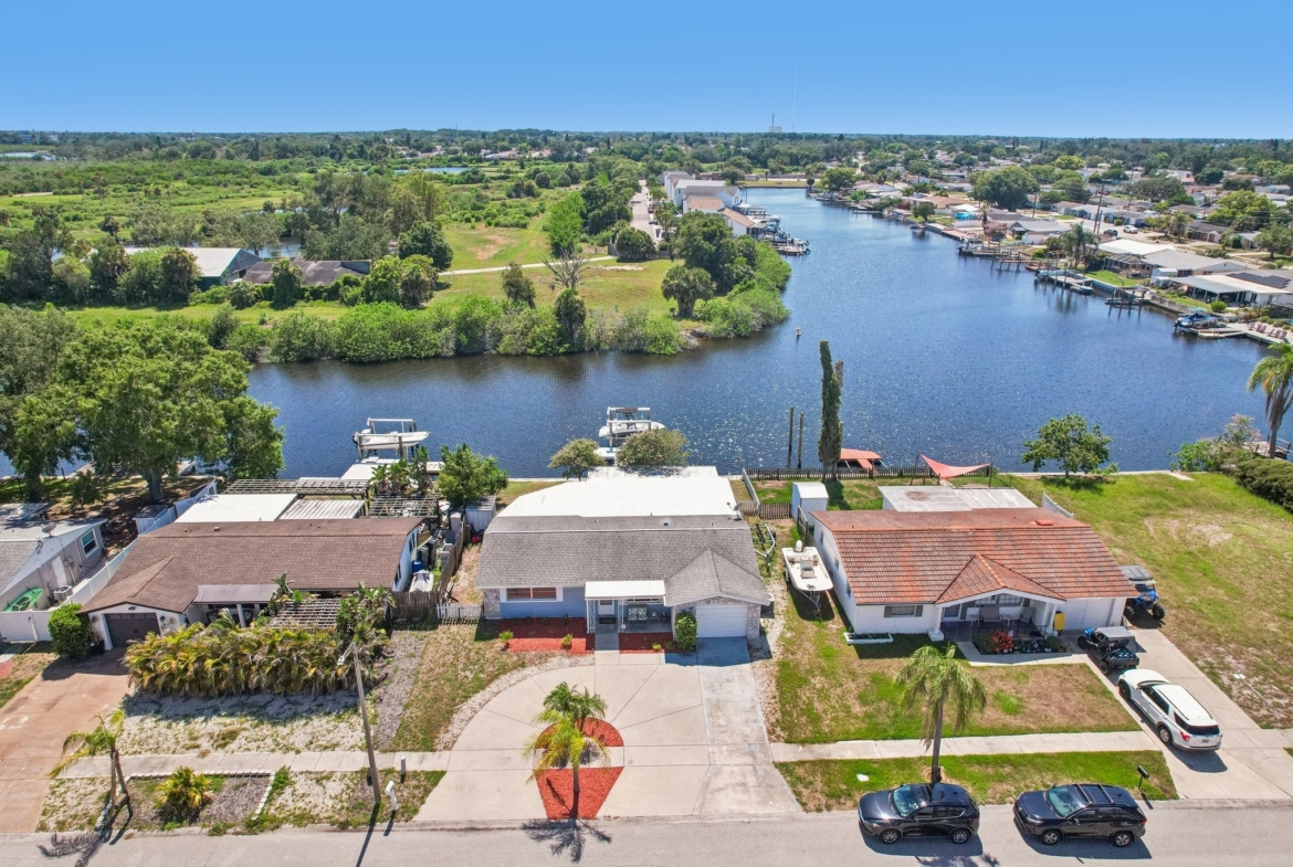 Aerial of 1133 Grand Blvd showing the circular driveway and canal in Forest Hills, Holiday FL 34690