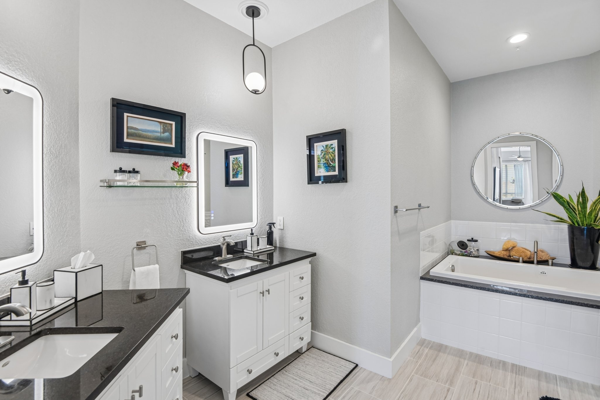 Primary bathroom with dual vanity, soaking tub and walk-in shower in this Clearwater Beach luxury condo for sale