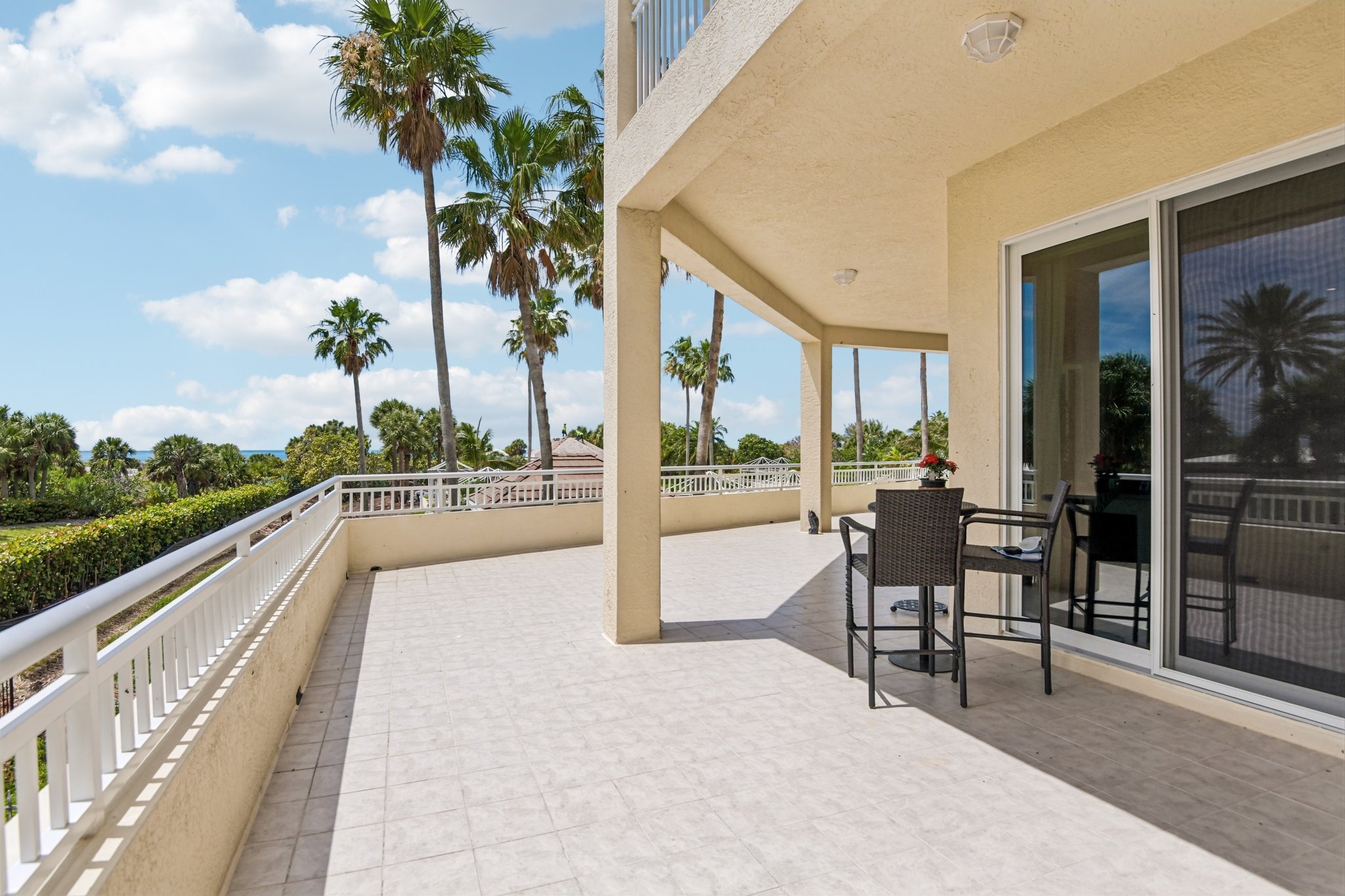 Oversized balcony terrace with Gulf and palm views at The Grande on Sand Key residence 101