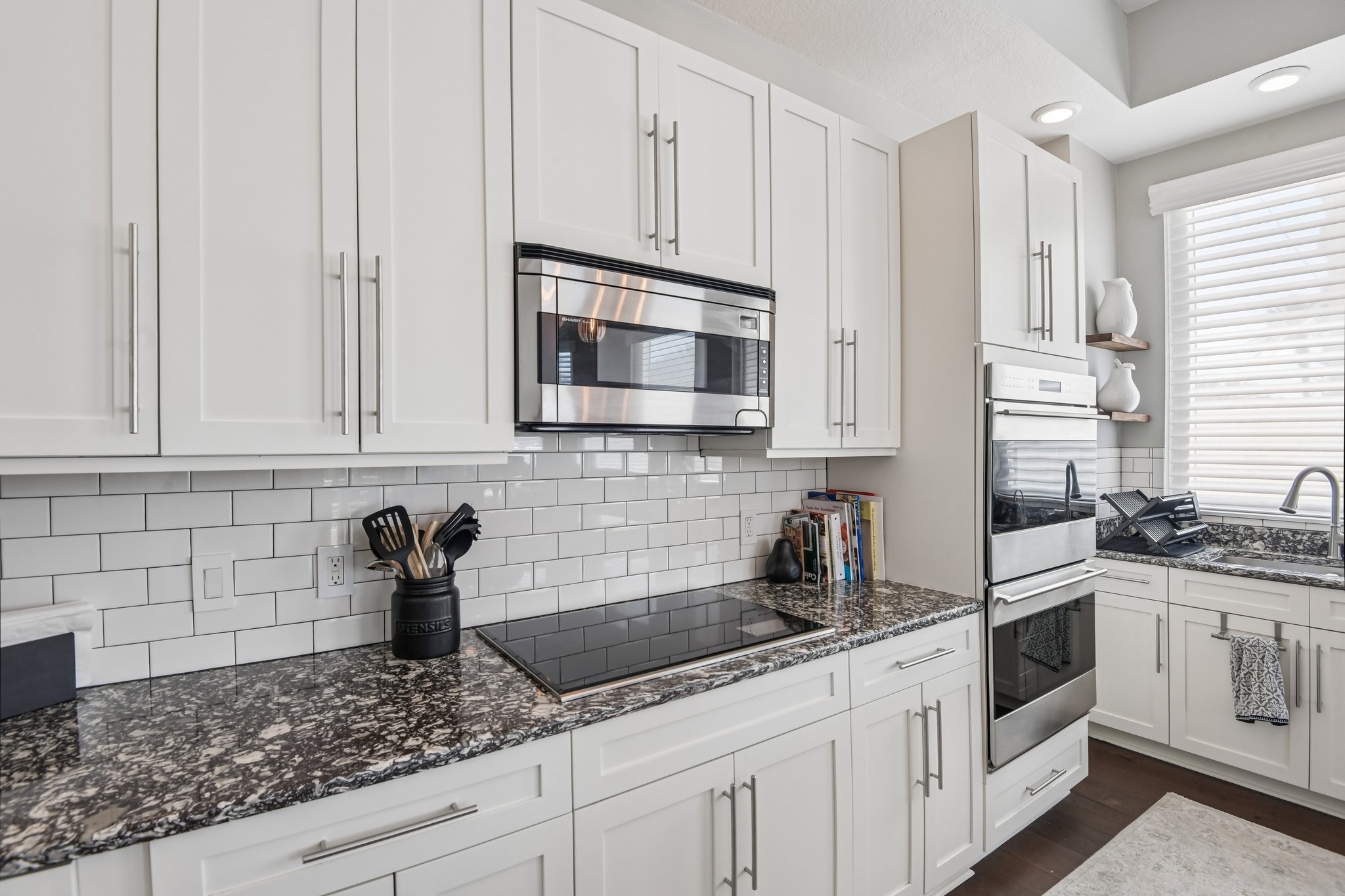 Kitchen with stone counters, solid wood cabinets and stainless appliances at The Grande on Sand Key #101