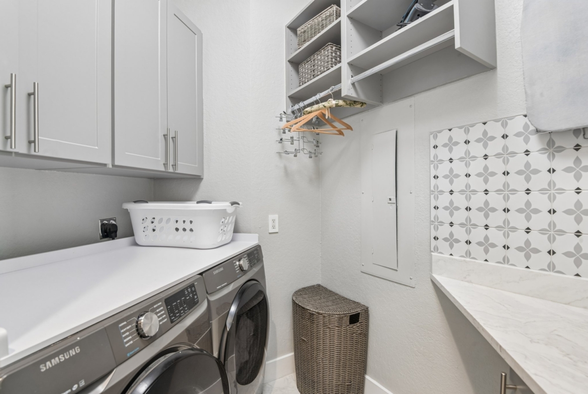 Butler's pantry with wine refrigerator and built-in features at The Grande on Sand Key residence 101