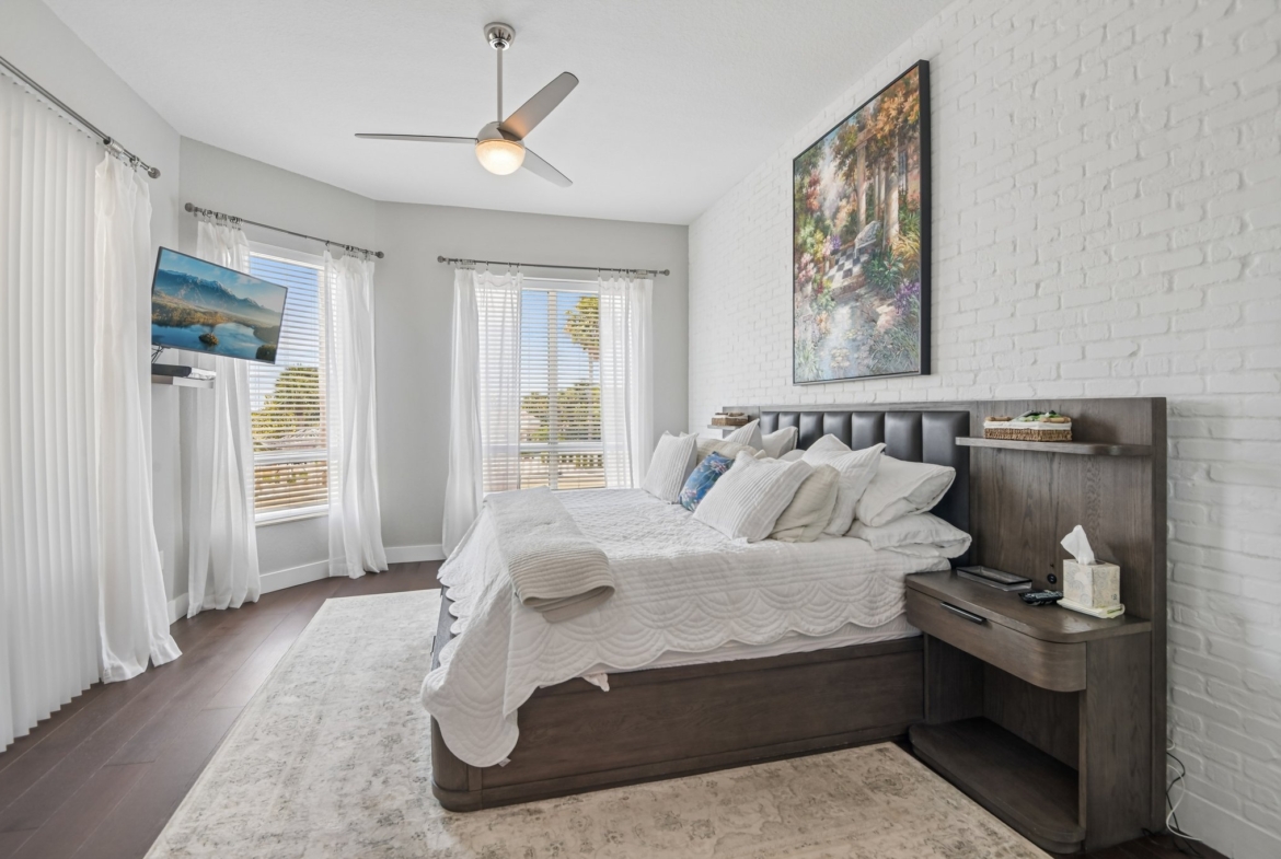 Guest bedroom with ceiling fan and natural light in this 3 bedroom Sand Key condo for sale