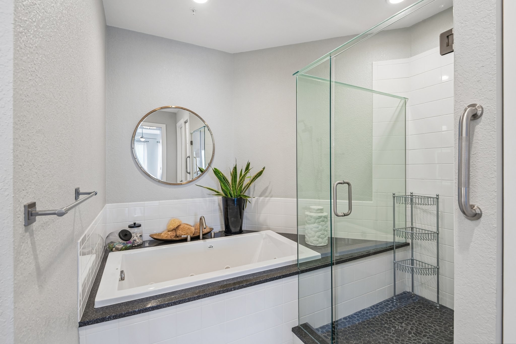 Primary bath with soaking tub and frameless glass shower at The Grande on Sand Key residence 101