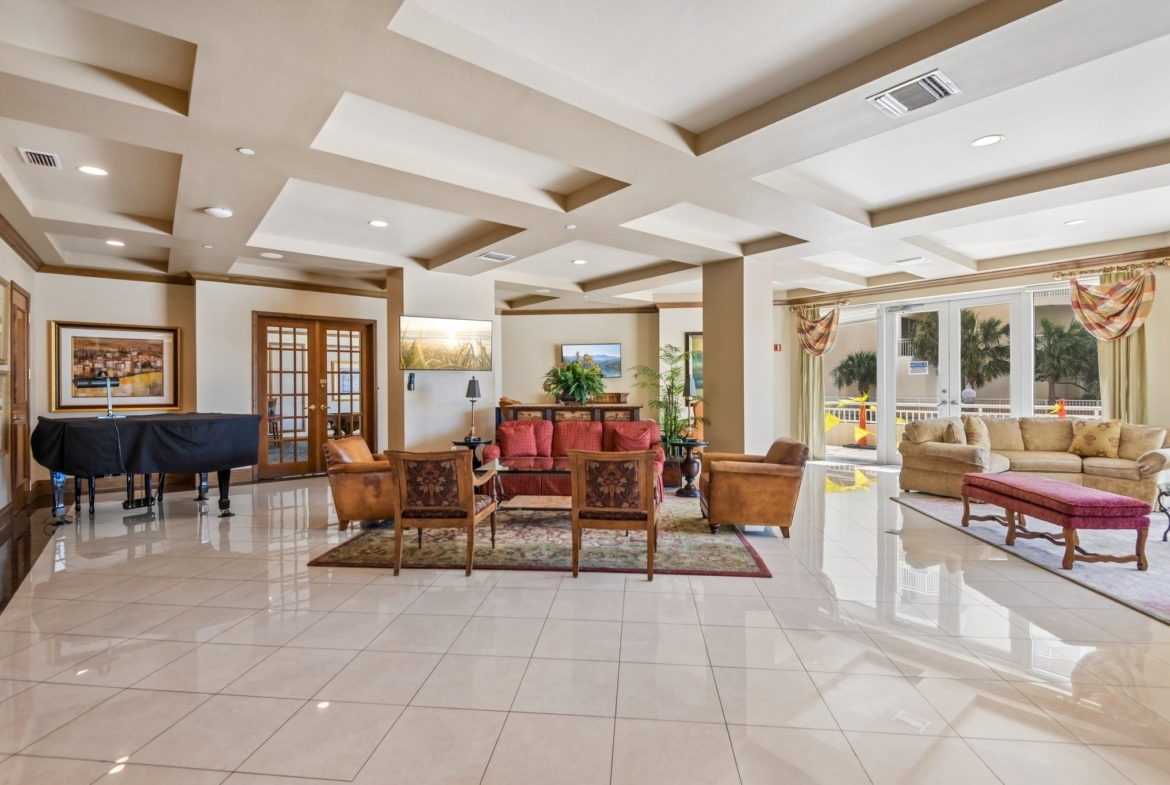 Elegant lobby social room with coffered ceilings at The Grande on Sand Key condominium