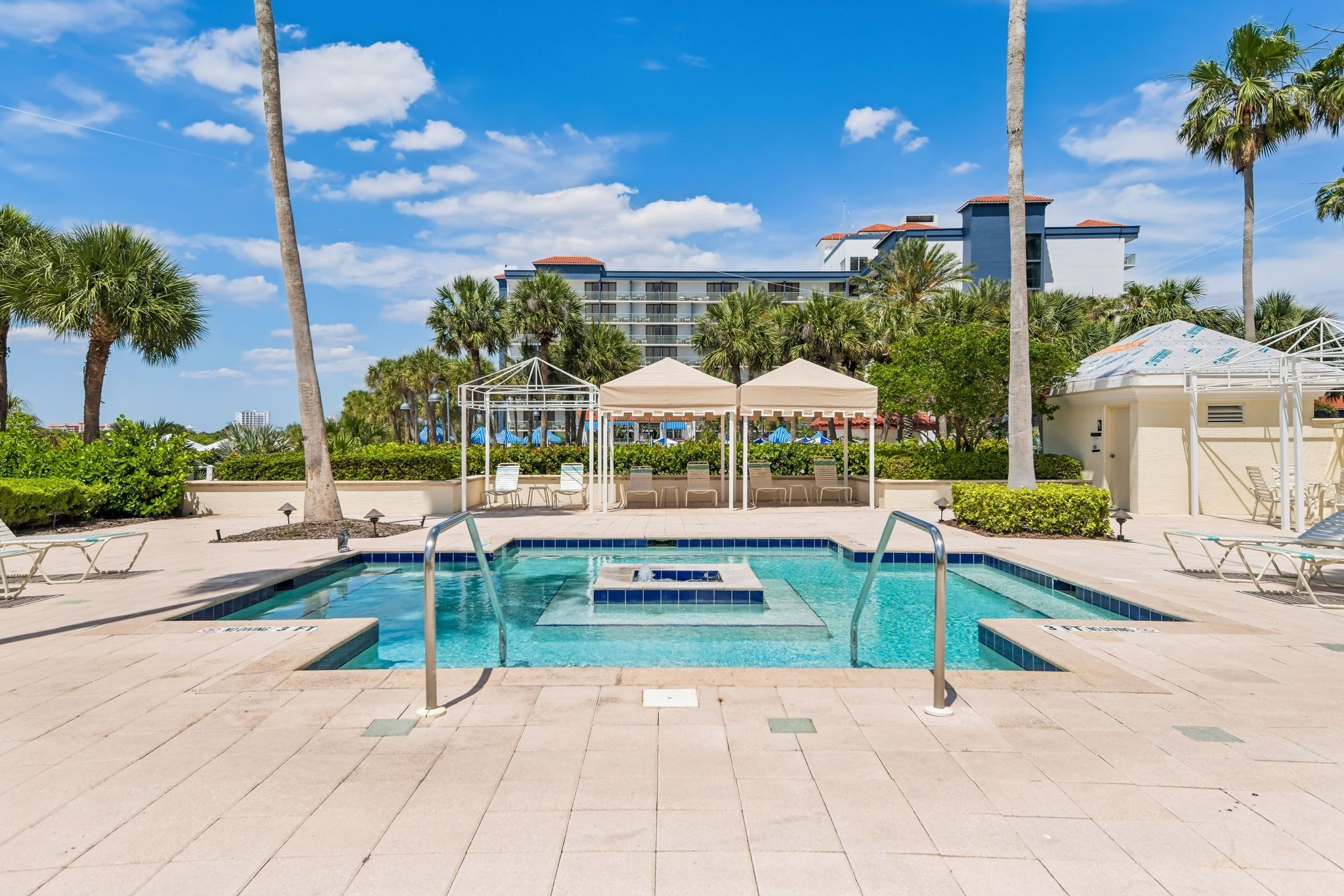 Resort-style heated gunite pool with private gazebos at The Grande on Sand Key, Clearwater Beach FL