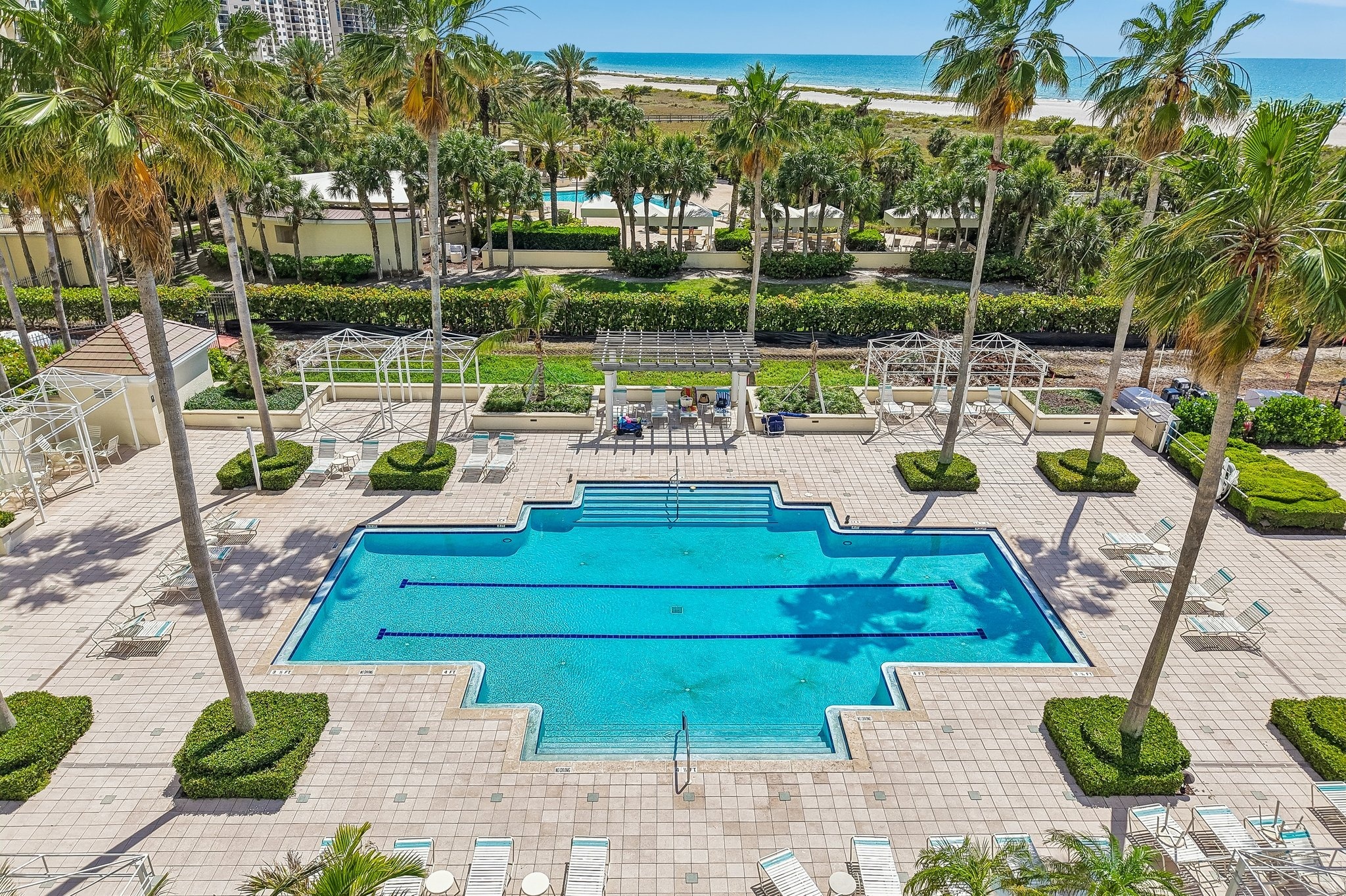 Aerial of the manicured grounds, resort pool and tennis complex at The Grande on Sand Key