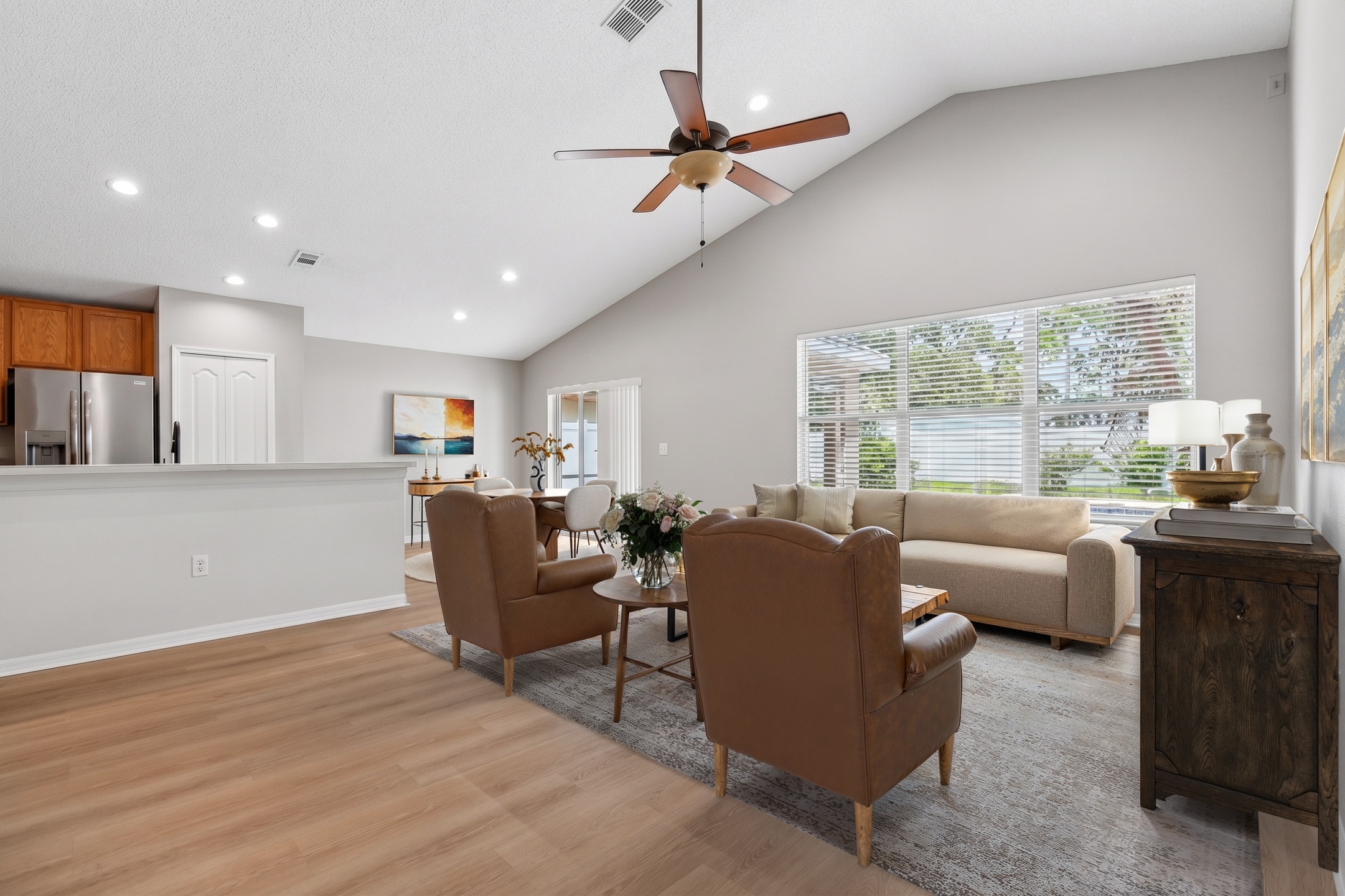 Bright living room with vaulted ceiling, ceiling fan and luxury vinyl plank flooring at 2638 Big Pine Dr, Holiday FL