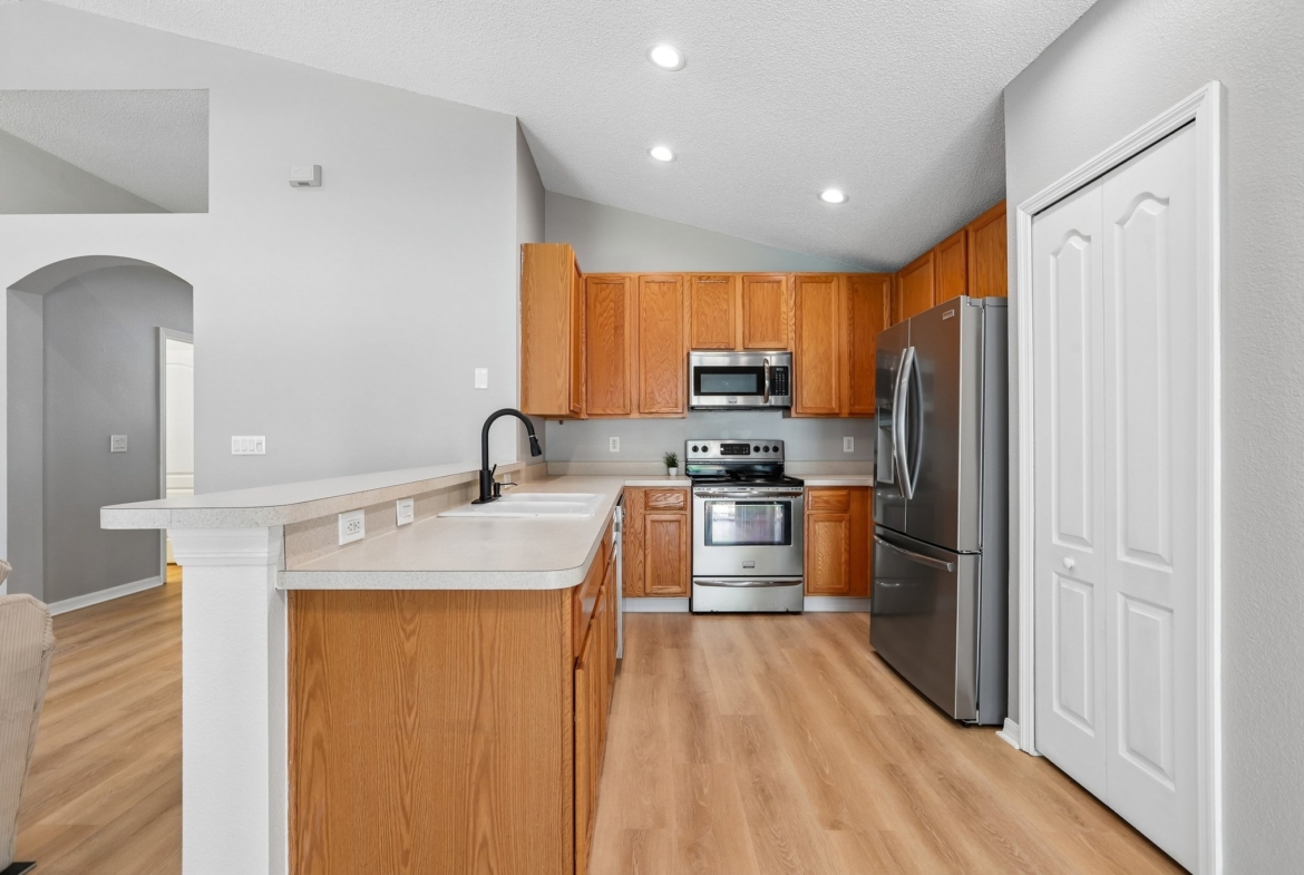 Updated kitchen with breakfast bar, stainless steel range and new French door refrigerator in Holiday FL home for sale