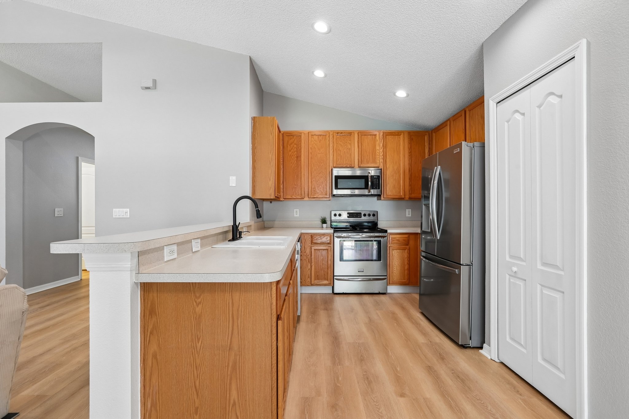 Updated kitchen with breakfast bar, stainless steel range and new French door refrigerator in Holiday FL home for sale