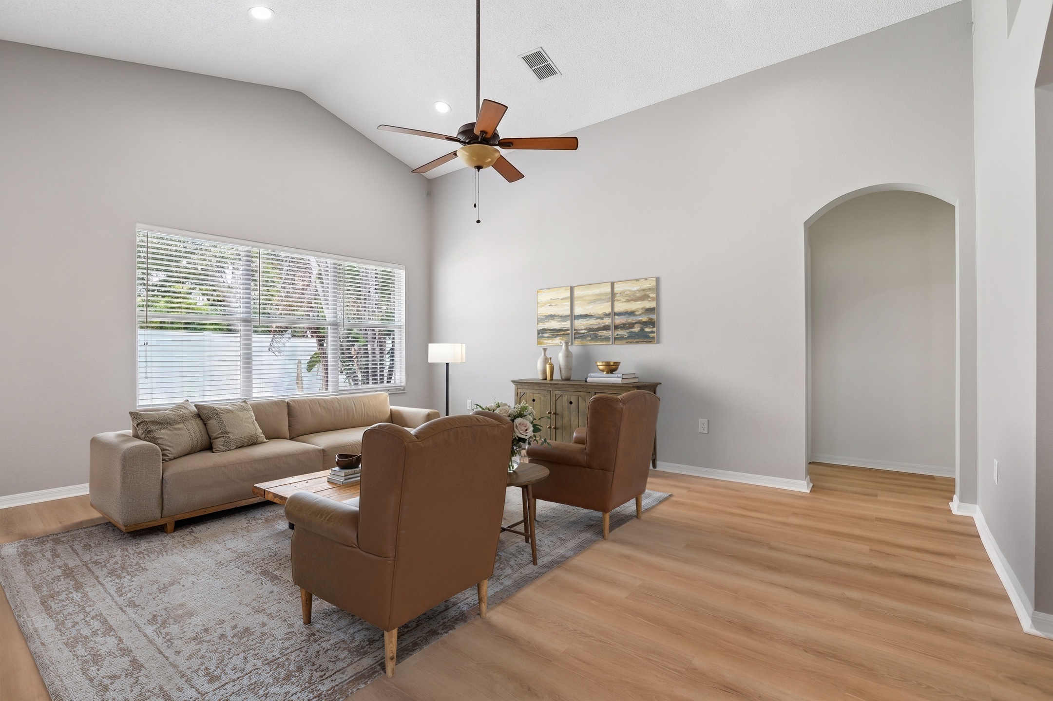 Virtually staged living room with ceiling fan and open floor plan in this Key Vista home for sale