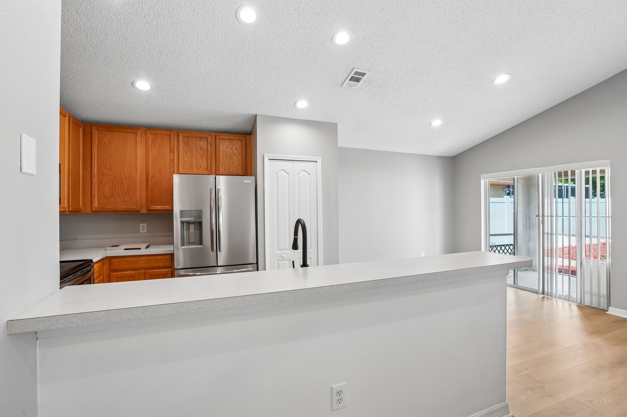 Kitchen and family room combo with solid surface counters and French door refrigerator, Holiday FL home for sale