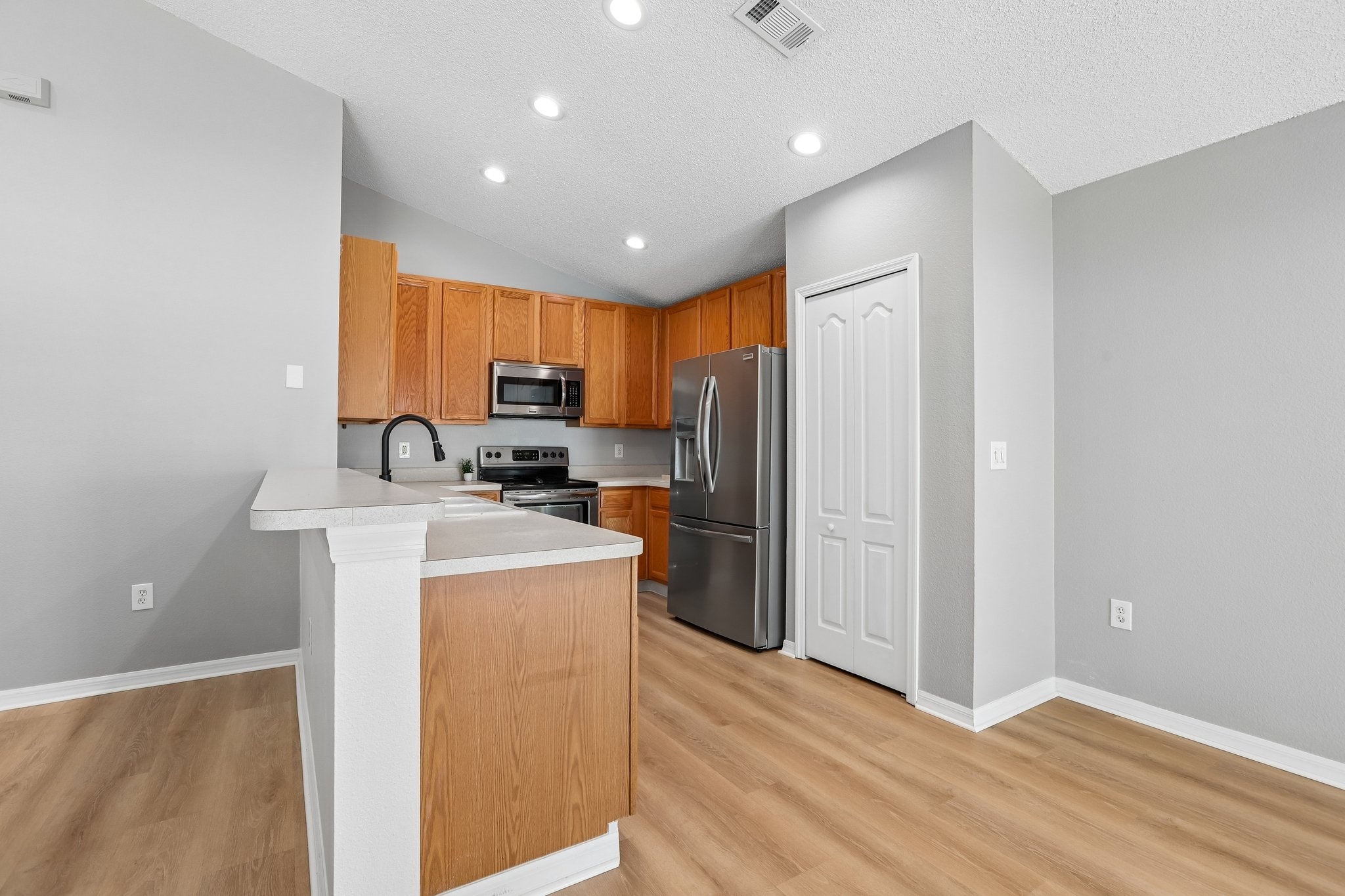 Eat in kitchen with stainless steel appliances and breakfast bar seating in Holiday FL 34691