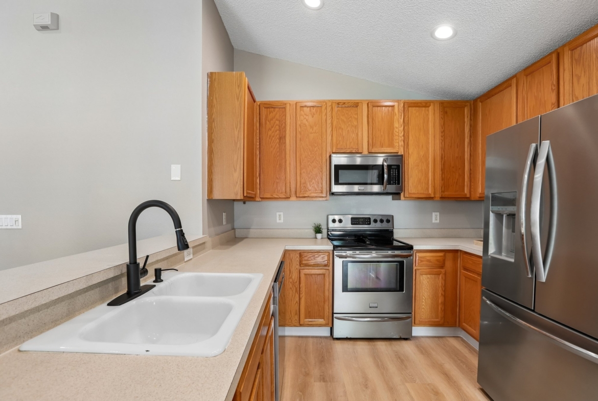 Kitchen sink with modern faucet, stainless range and microwave at 2638 Big Pine Dr, Holiday FL