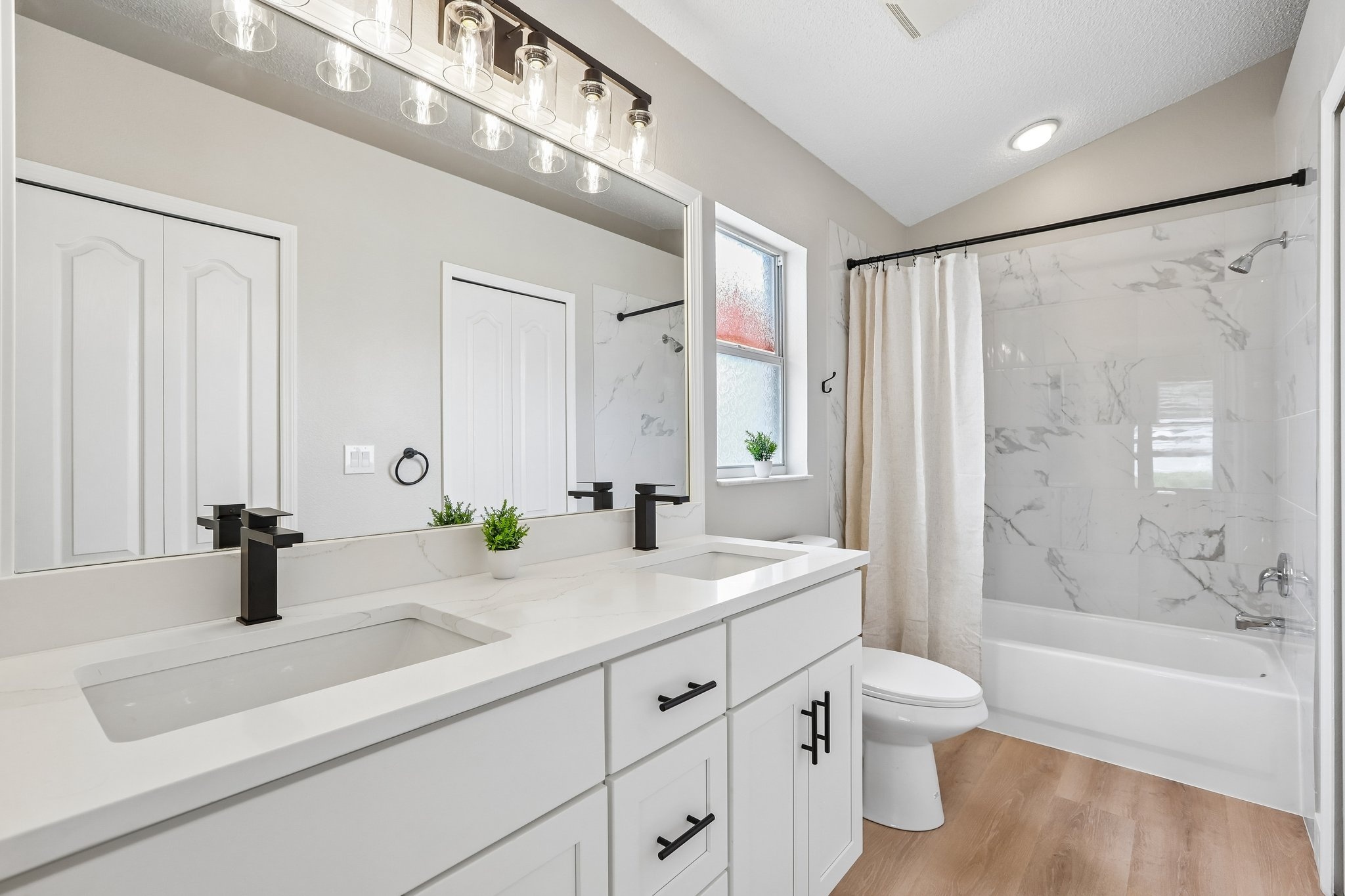 Updated primary bathroom with dual sink vanity and tub shower combination, Holiday FL home for sale