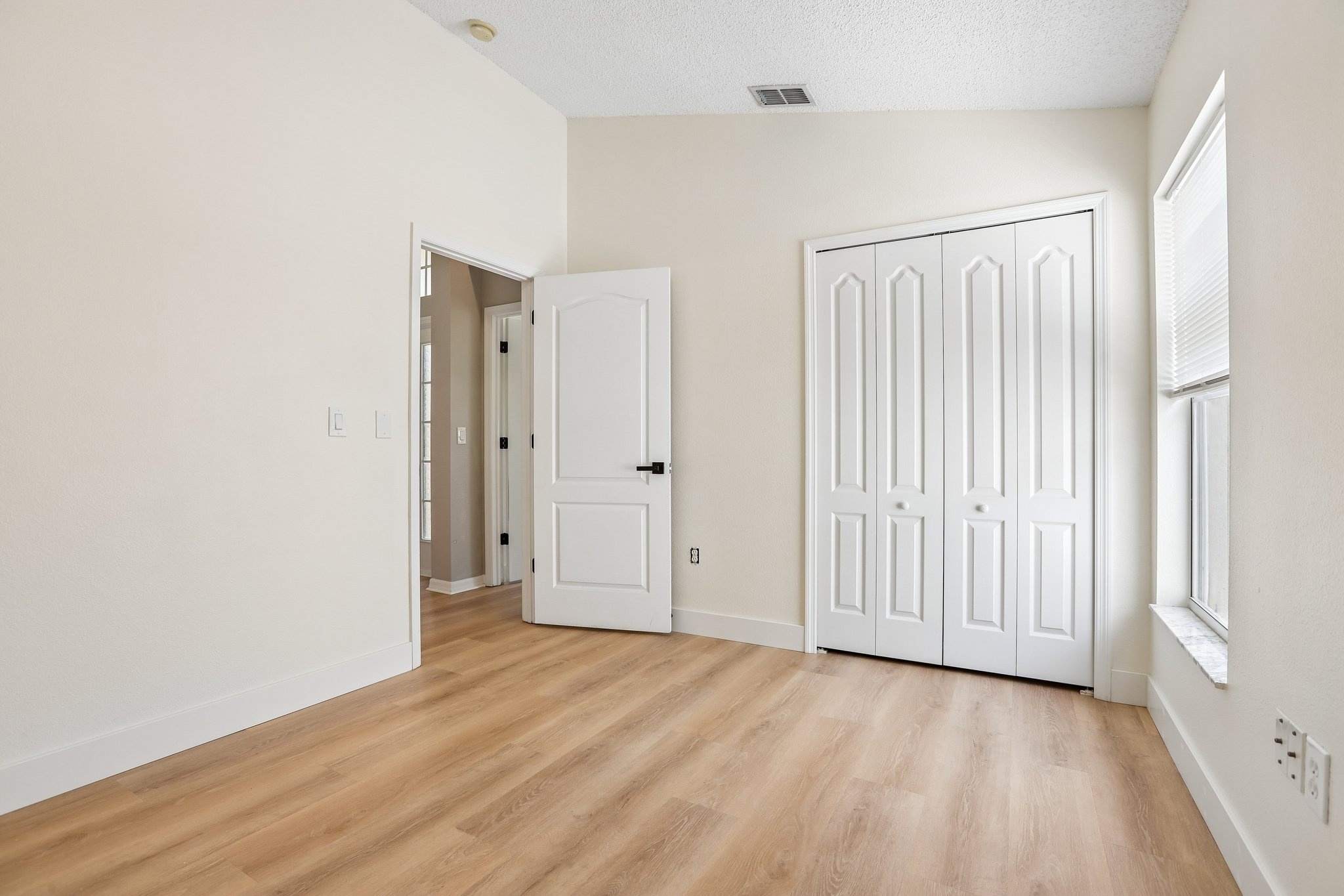 Bedroom with double closet and luxury vinyl plank flooring in Key Vista, Holiday FL
