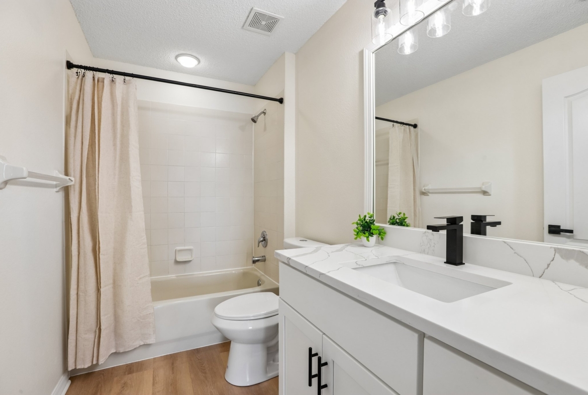 Updated guest bathroom with tub shower and modern vanity at 2638 Big Pine Dr, Holiday FL