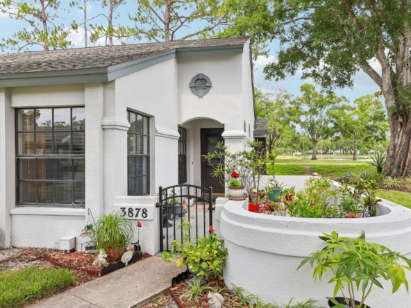 Front entry with private gated courtyard at 3878 Tanager Pl, an end-unit villa for sale in Palm Harbor, FL 34685