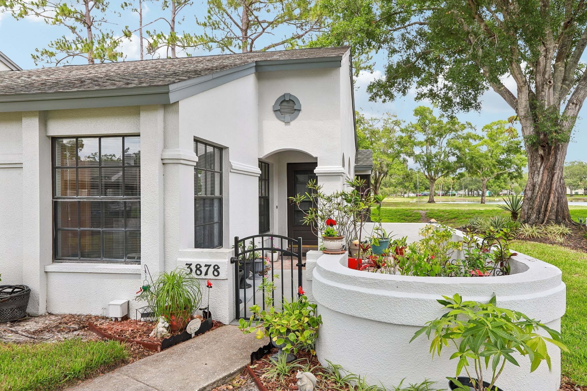 Front entry with private gated courtyard at 3878 Tanager Pl, an end-unit villa for sale in Palm Harbor, FL 34685