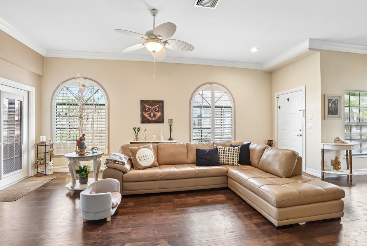 Spacious living room with crown molding, arched windows and vaulted ceiling at 3878 Tanager Pl, Palm Harbor FL