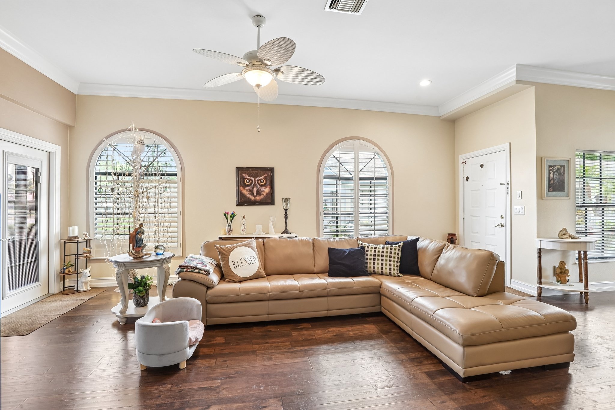 Spacious living room with crown molding, arched windows and vaulted ceiling at 3878 Tanager Pl, Palm Harbor FL
