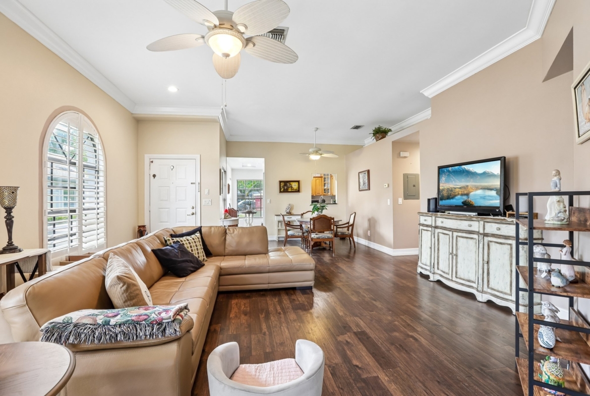 Open living and dining combo with laminate flooring in this Palm Harbor end-unit villa for sale