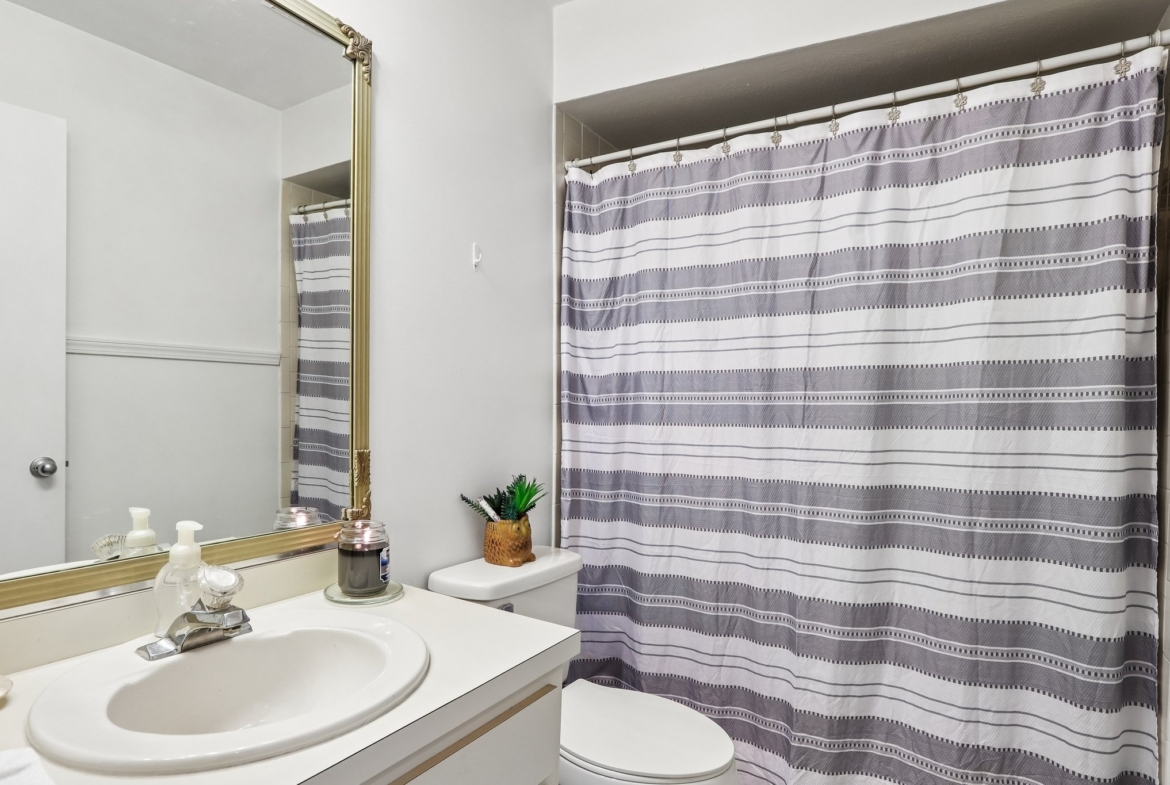 Guest bathroom with vanity and tub shower combination in this Palm Harbor villa