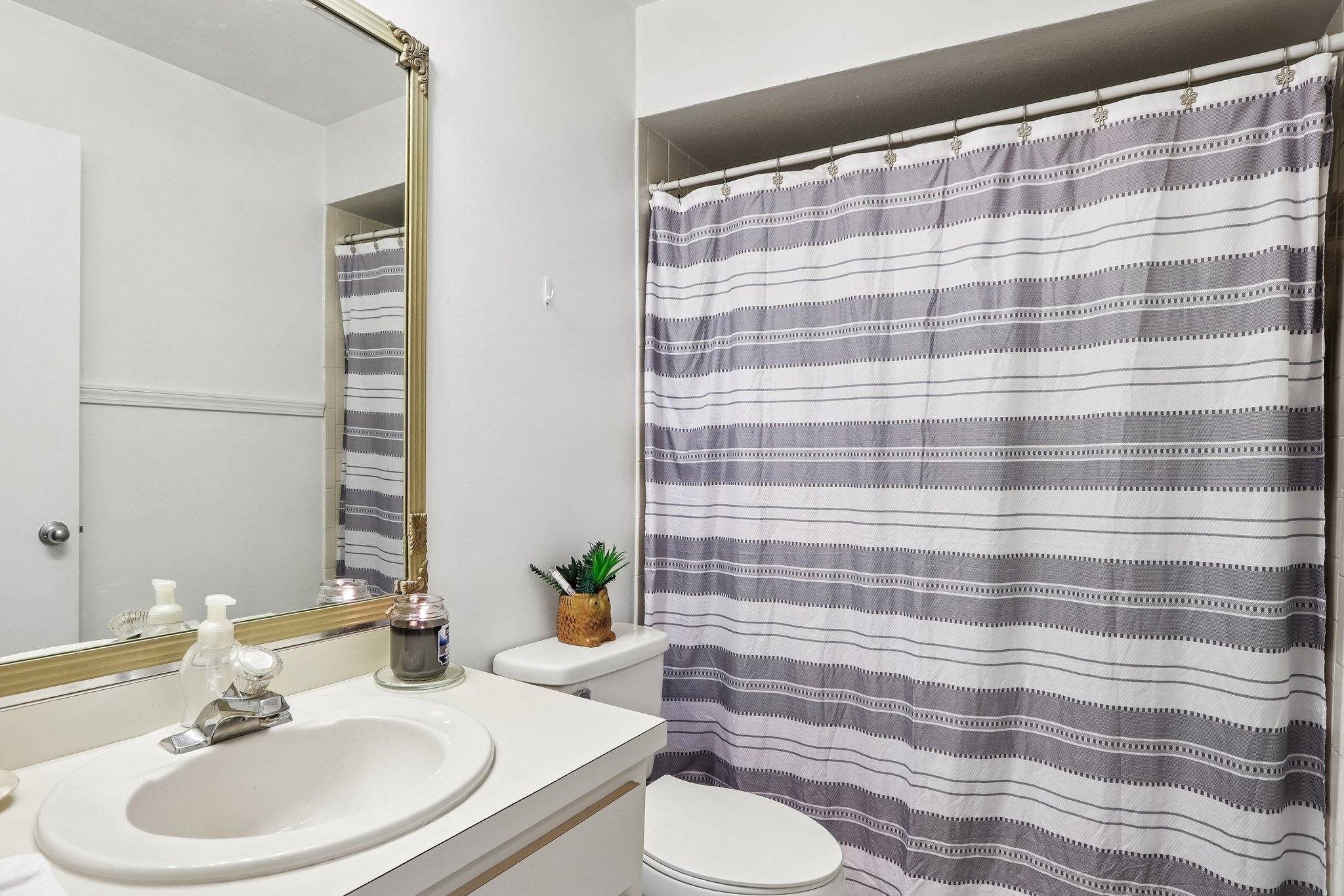 Guest bathroom with vanity and tub shower combination in this Palm Harbor villa