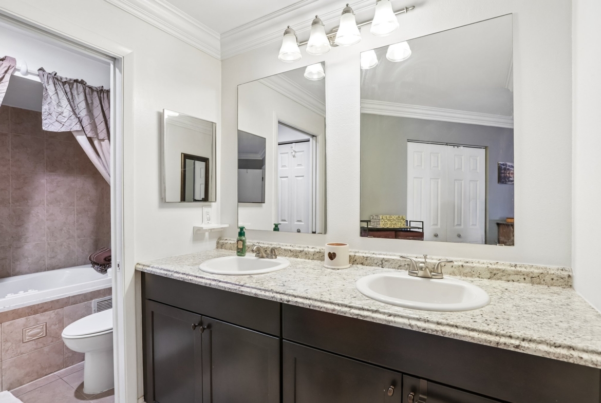 Primary bathroom with double vanity and ceramic tile at 3878 Tanager Pl, Palm Harbor, FL 34685
