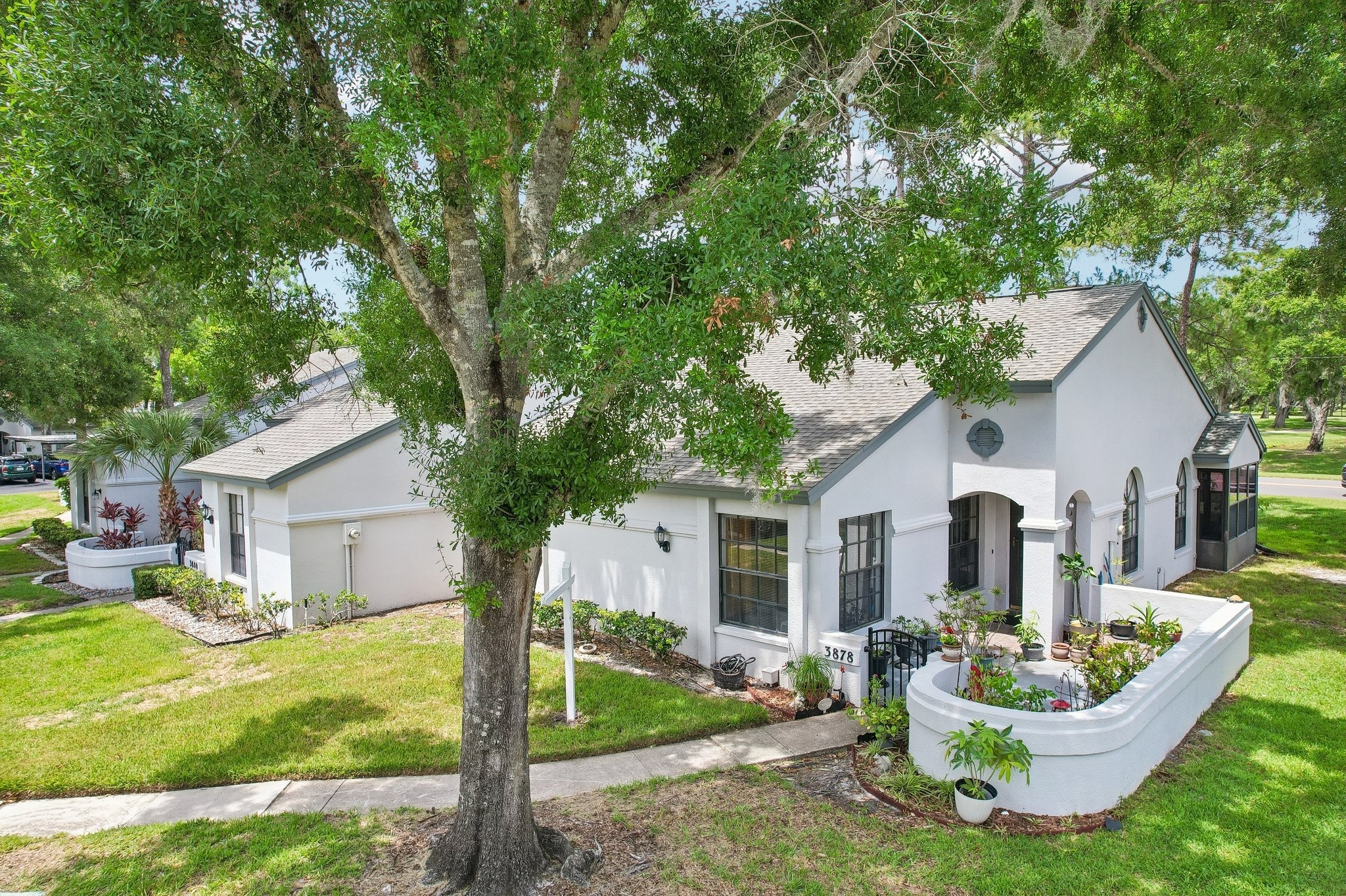 Front of the villa shaded by a mature oak at 3878 Tanager Pl, Palm Harbor FL