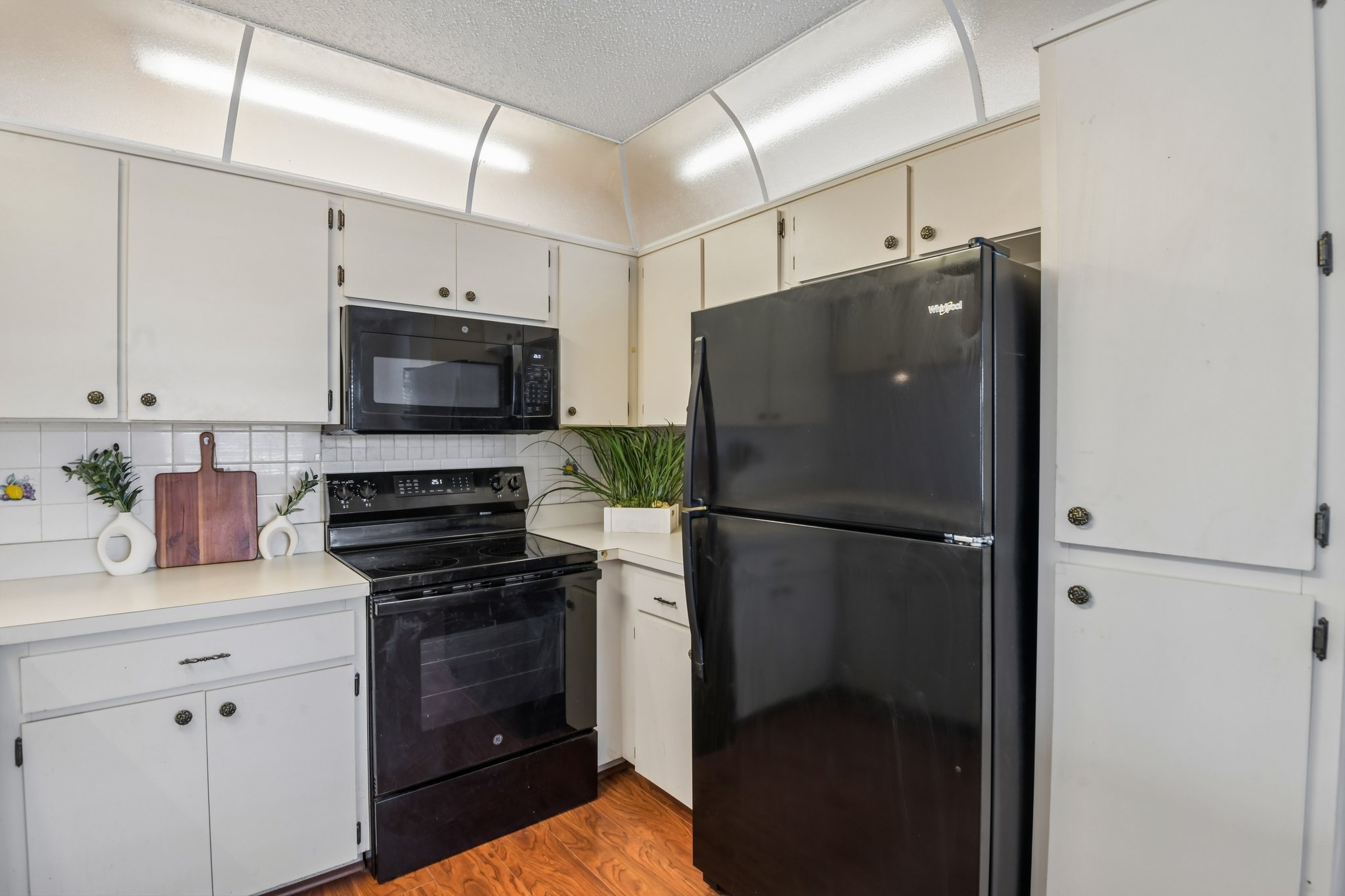 Kitchen with electric range and refrigerator in this newly painted Hudson FL 55+ condo