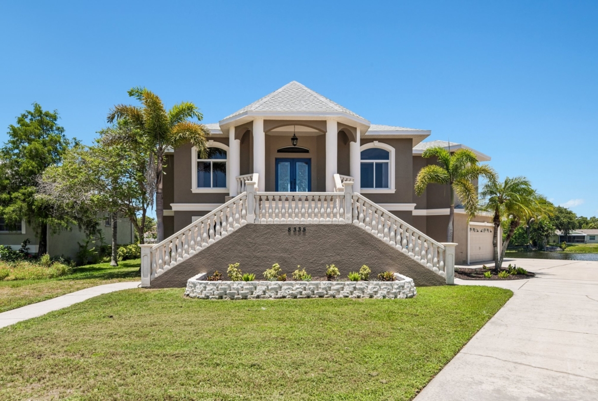 Front exterior of 8335 Cheyenne Dr, a custom-built 4 bedroom waterfront estate for sale in Seminole, FL 33777