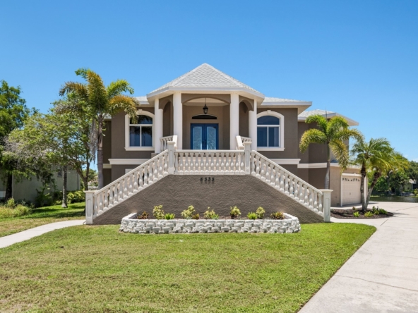 Front exterior of 8335 Cheyenne Dr, a custom-built 4 bedroom waterfront estate for sale in Seminole, FL 33777
